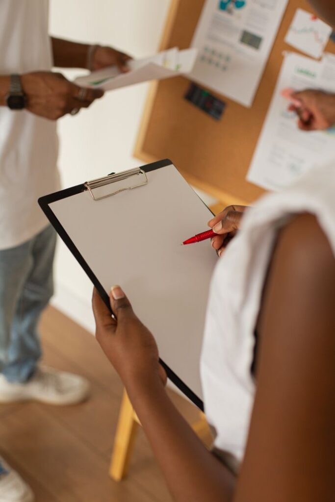 Adults working together in an office, focusing on notes and teamwork dynamics.